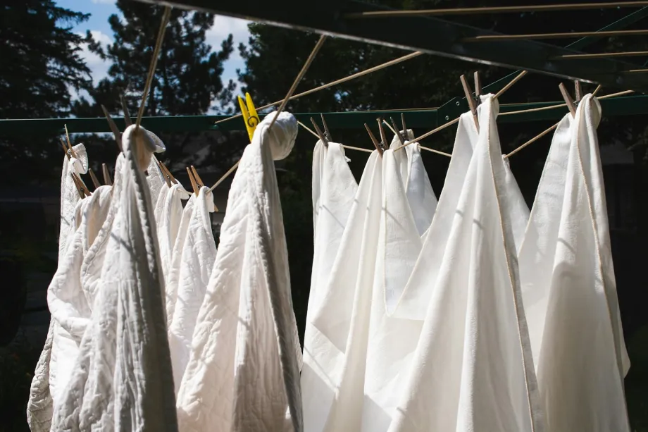 White sheets hanging on a washing line in daylight