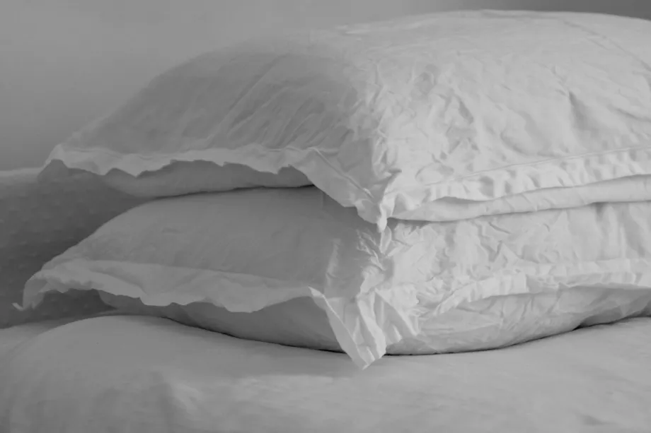 Black and white close-up of a creased linen pillow on a bed