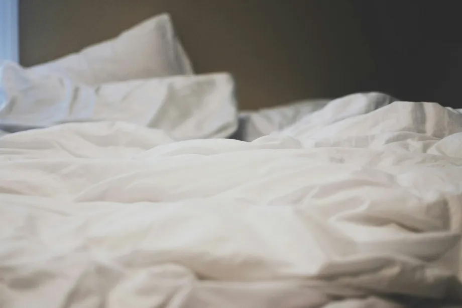 Soft white bed linen with folds catching the light