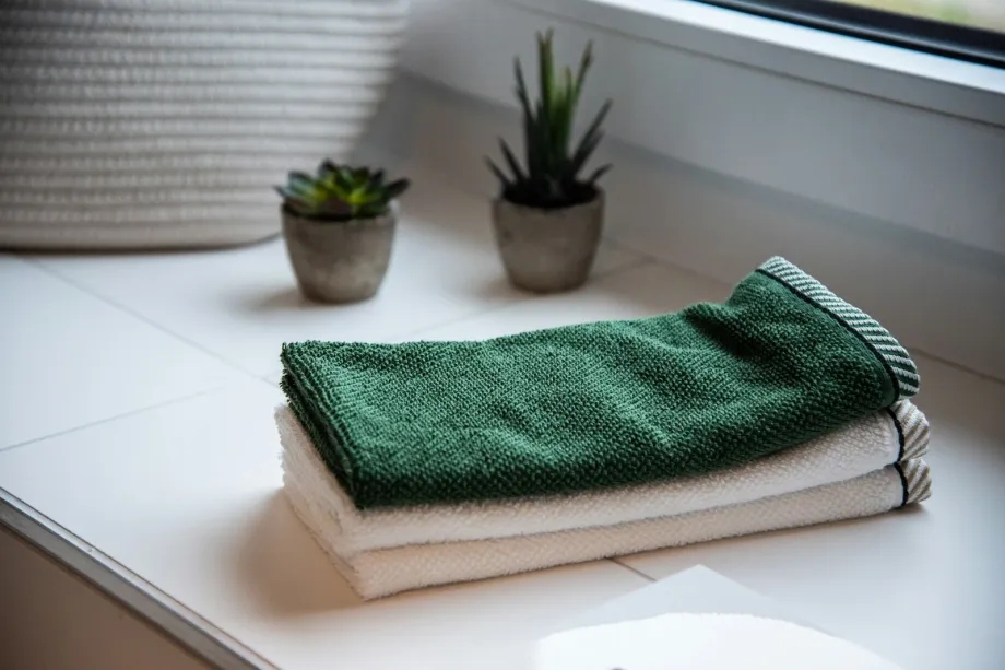 Folded towels stacked beside potted plants