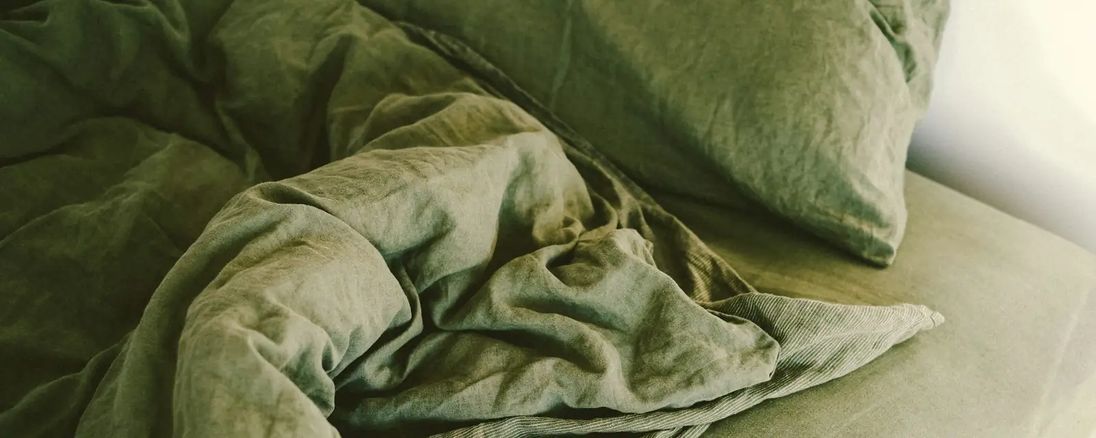 A made bed with a soft blanket in a calm bedroom